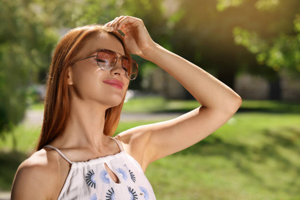 istock Beautiful woman wearing sunglasses in park, space for text 1922425756