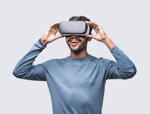 istock Happy surprised man using virtual reality eyeglasses headset, isolated on grey background 1922434239