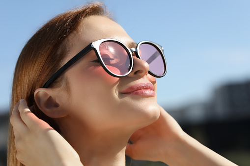 Beautiful woman in sunglasses outdoors, closeup. Space for text