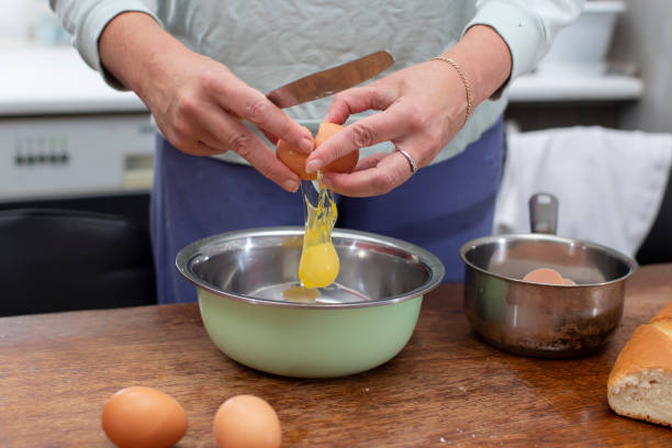 istock Cook breakfast. Hands break eggs to prepare an omelet. 1922435303