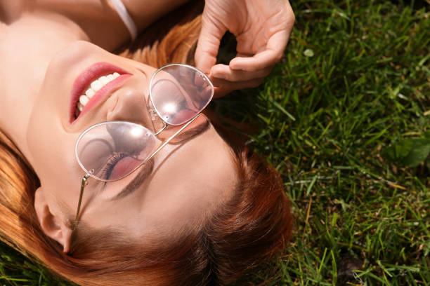 istock Beautiful woman in sunglasses on green grass outdoors, space for text 1922439014