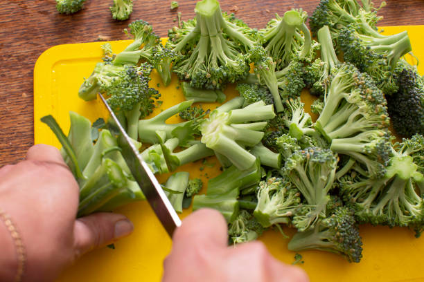 istock Hands cutting broccoli cabbage. Healthy green vegetables. 1922441697