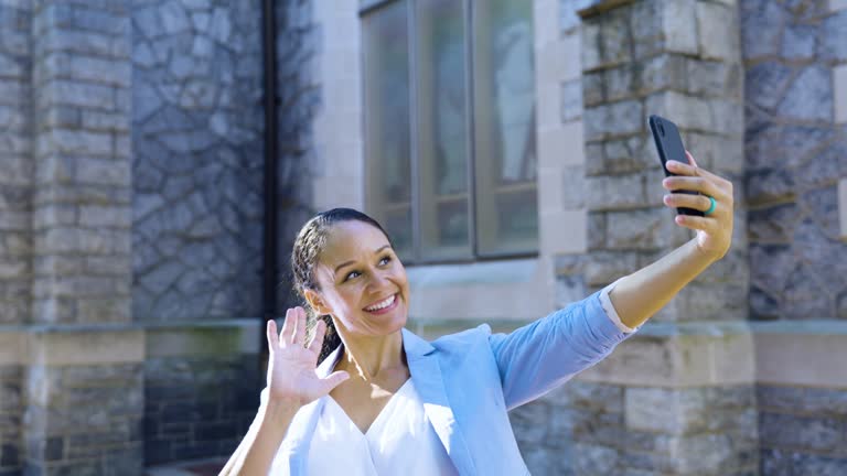 Multiracial woman by historic building takes selfie