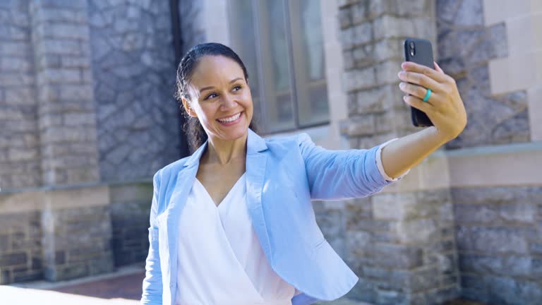 Multiracial woman by historic building takes selfie