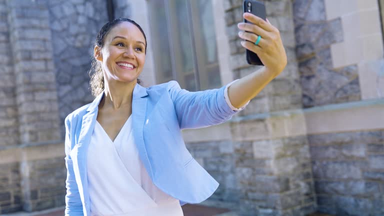 Multiracial woman by historic building takes selfie