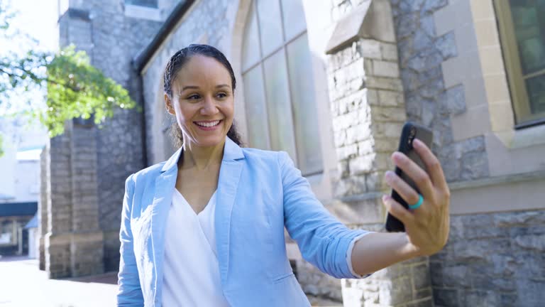 Multiracial woman by historic building takes selfie