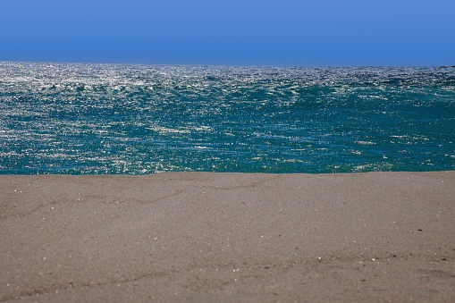 Three-part image of a white sandy beach in front of turquoise-green water and blue sky during the day