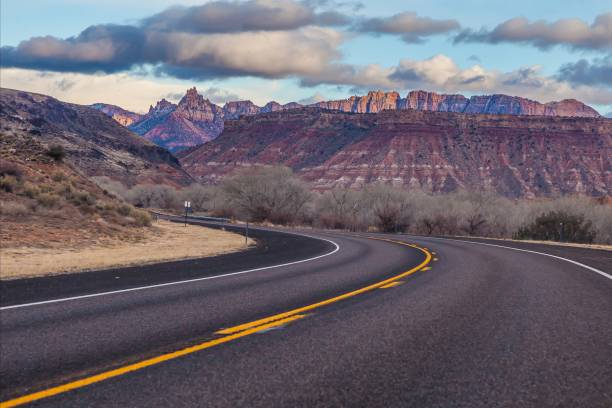 istock Panoramic picture of a lonely road through mountainous desert 1922459667