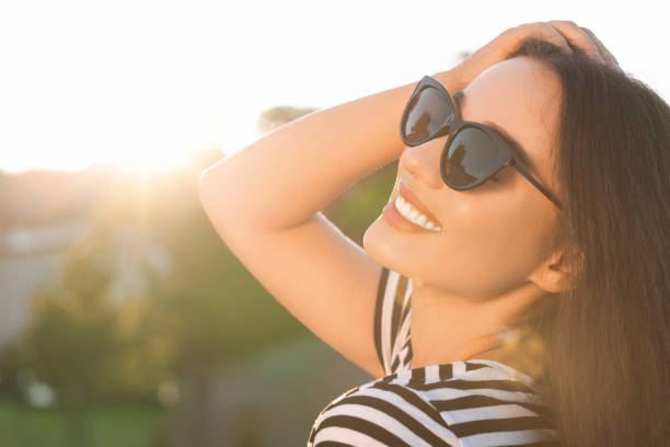 istock Beautiful smiling woman in sunglasses outdoors, space for text 1922460224