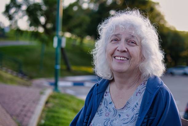 istock Attractive grey-haired curly senior woman smiling while looking at the camera. Copy space. 1922463919