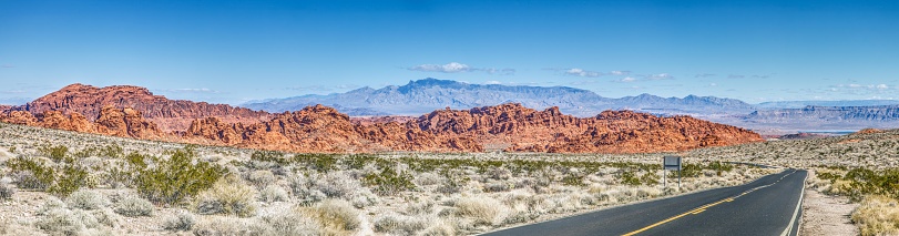 Panoramic picture of a lonely road through mountainous desert during the day