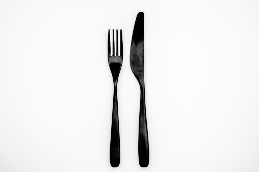 Black knife and fork on white background