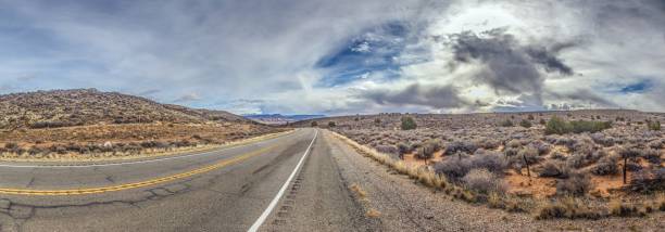 istock Panoramic picture of a lonely road through mountainous desert 1922500473