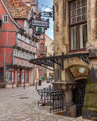 Quedlinburg, Germany – October 31, 2023: A grand old building stands stoically between two other structures, their windows reflecting the sun