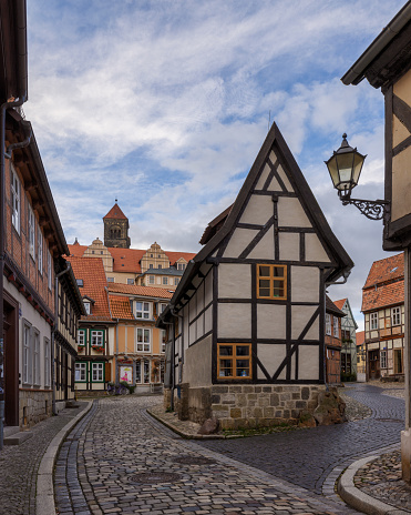Quedlinburg, Germany – October 31, 2023: A picturesque cobblestone road leads to a charming European-style building with white and brown hues