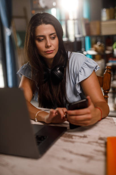istock Young woman checking her text messages on smart phone when working 1922531005