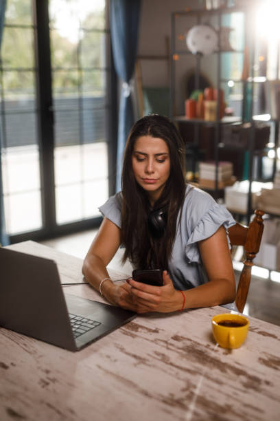 istock Young woman checking her text messages on smart phone when working 1922531548