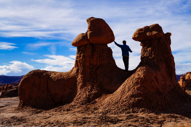 istock Man in Silhouette Standing Between Rock Hoodoo Formations 1922540978