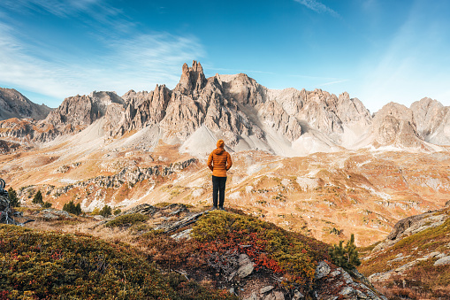 Achievement of female hiker standing with enjoying the massif Des Cerces in Claree Valley during hiking trail in French Alps, France