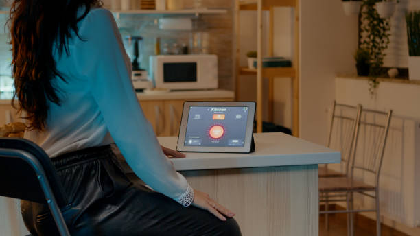 istock Woman looking at tablet in house with automation lighting system 1922572394