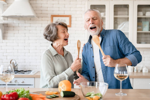 istock Elderly couple  singing dancing at home kitchen while cooking dinner 1922578767