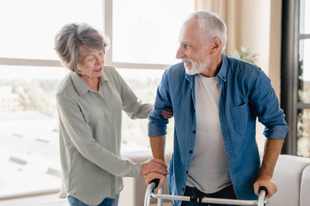 istock Supportive old woman helping her disabled incapacitated husband 1922580482