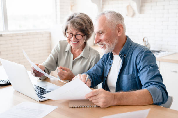 istock Smiling husband and wife using laptop and doing paperwork together 1922591127