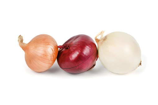 Three onion bulbs of different colors (red, yellow and white) isolated on white background. High resolution photo. Full depth of field.