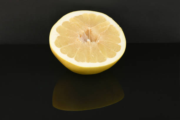 Pomelo isolated on acrylic black background. High resolution photo. Full depth of field.