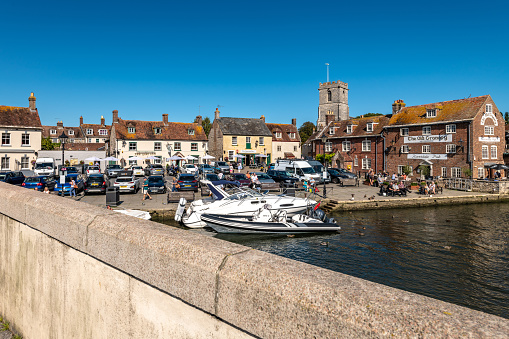 Wareham, UK. 4 September 2023. Bridge over the River Frome in Wareham with quayside and boats.
