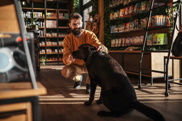 istock Young Man and Labrador in the Pet Store 1922616070