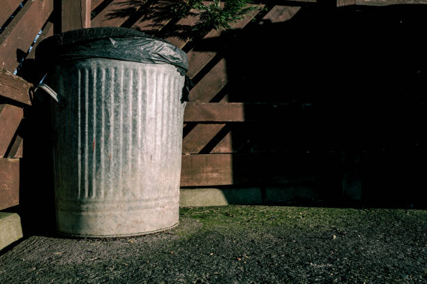 istock Old style metal dustbin seen in a corner of a housing development. 1922626123