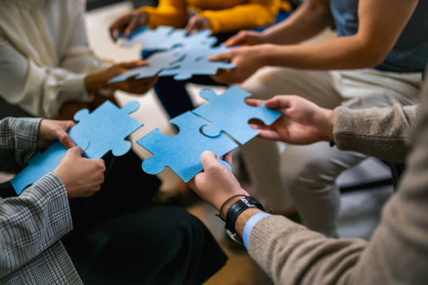 istock Group of professional people playing puzzle in the office 1922627729