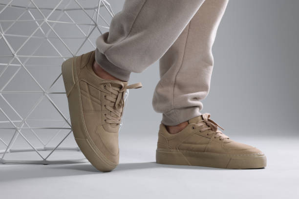 istock Man wearing stylish sneakers on light grey background, closeup 1922630372