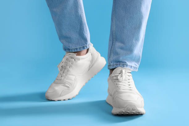 istock Man walking in stylish sneakers on light blue background, closeup 1922631452