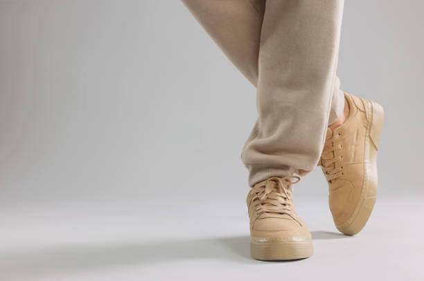 istock Man wearing stylish sneakers on light grey background, closeup. Space for text 1922631475