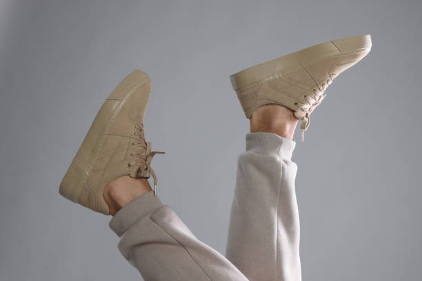 istock Man wearing stylish sneakers on light grey background, closeup 1922631981