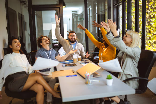 istock International workers group throwing all the paperwork after being done with project. 1922634730