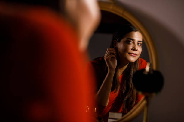 istock Woman looking in the mirror, fixing her appearance 1922646911