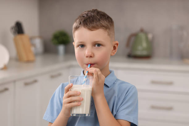 istock Cute boy drinking fresh milk from glass indoors 1922661241