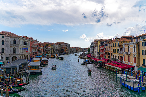 Old town of City of Venice with Grand Canal and gondolas at Rialto Pier on a blue cloudy summer day. Photo taken August 6th, 2023, Venice, Italy.