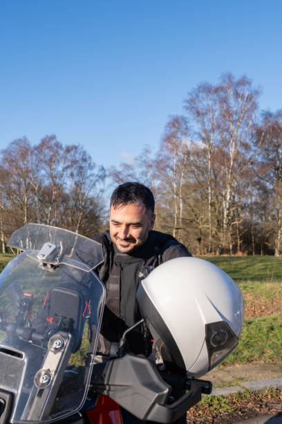 istock Biker man standing next to his bike happy 1922693763