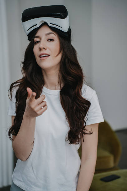 istock Creative professional with VR headset gestures in mid-explanation, immersed in a virtual meeting, blending technology and communication 1922696385
