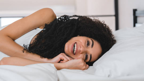 istock Amused african young woman lying in comfortable bed 1922701714