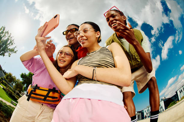széles látószögű felvétel a z generációs baráti társaságról, akik együtt használnak egy okostelefont. - ifjúsági kultúra témájú stock jellegű vizuális alkotások, jogdíjmentes fotók és képek