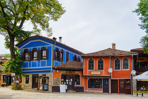Koprivshtitsa, Bulgaria - September 24, 2023: Street scene with cafe, shops, locals, and visitors, in Koprivshtitsa, Bulgaria
