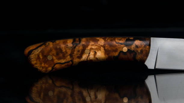 istock Knife with bush-hammered birch on black glass 1922758608