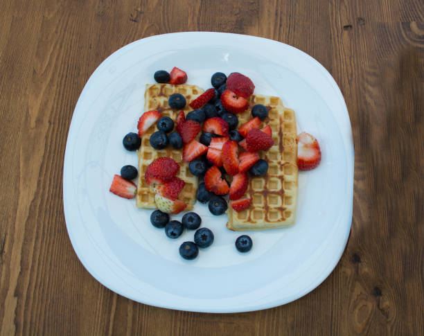 Close-up delicious pancakes, with fresh blueberries, strawberries and maple syrup