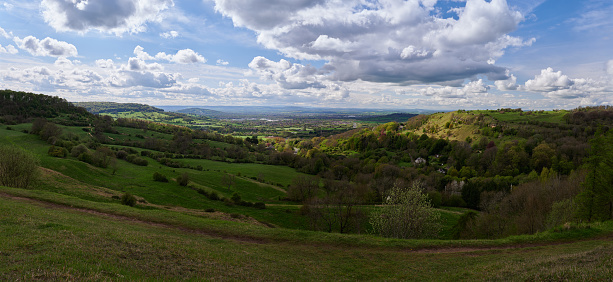 Rolling hills over English countryside with blue sky and white clouds in panorama