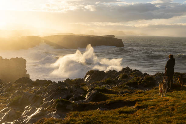 femme prenant une photo de la côte océanique à bufones de pria dans les asturies, au nord de l’espagne, par une journée venteuse avec une mer agitée - individual event photos et images de collection